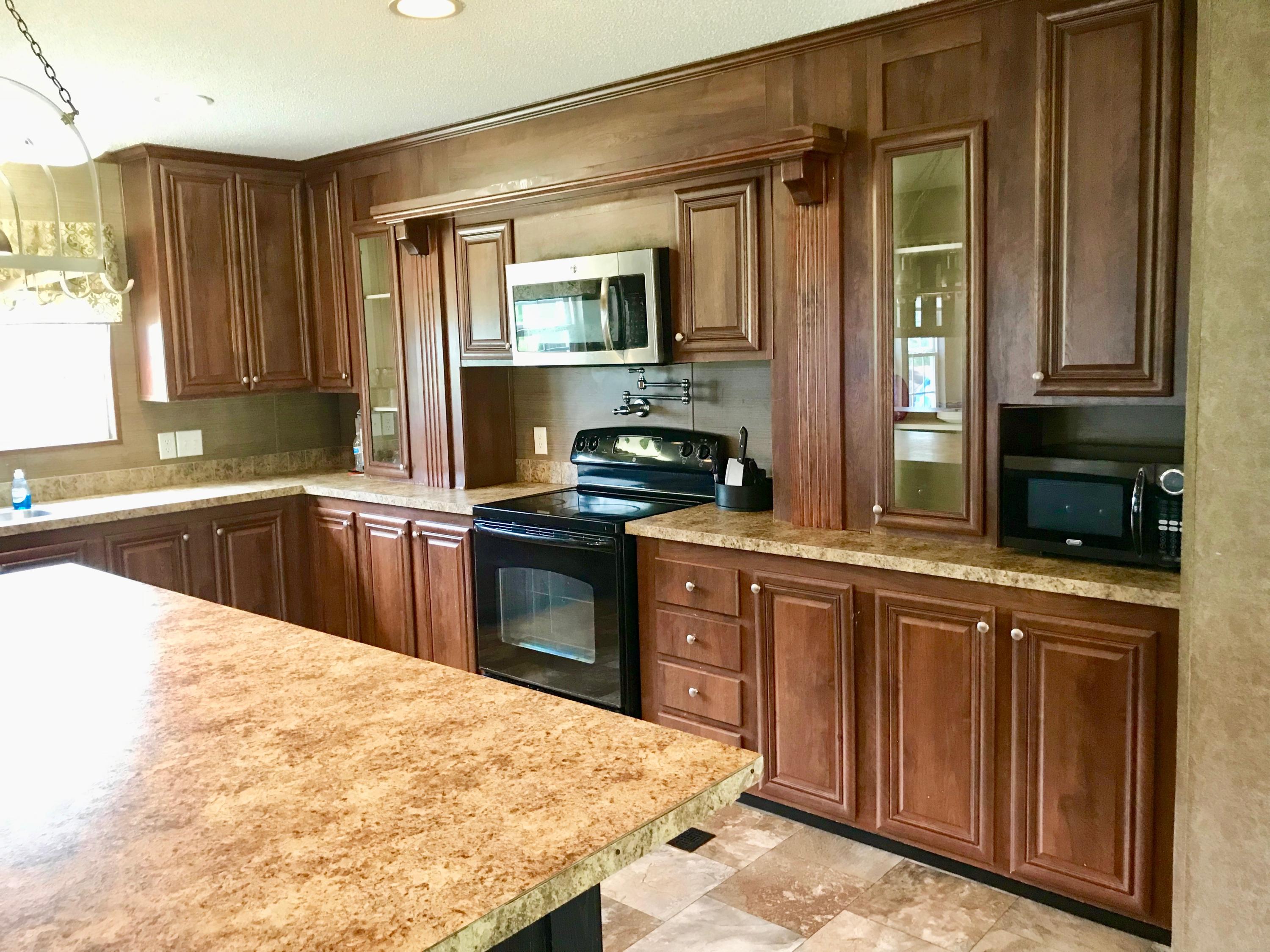 9840 American Farms Road Milton, FL 32583 - Photo 9 of 42 a kitchen with granite countertop a sink and cabinets