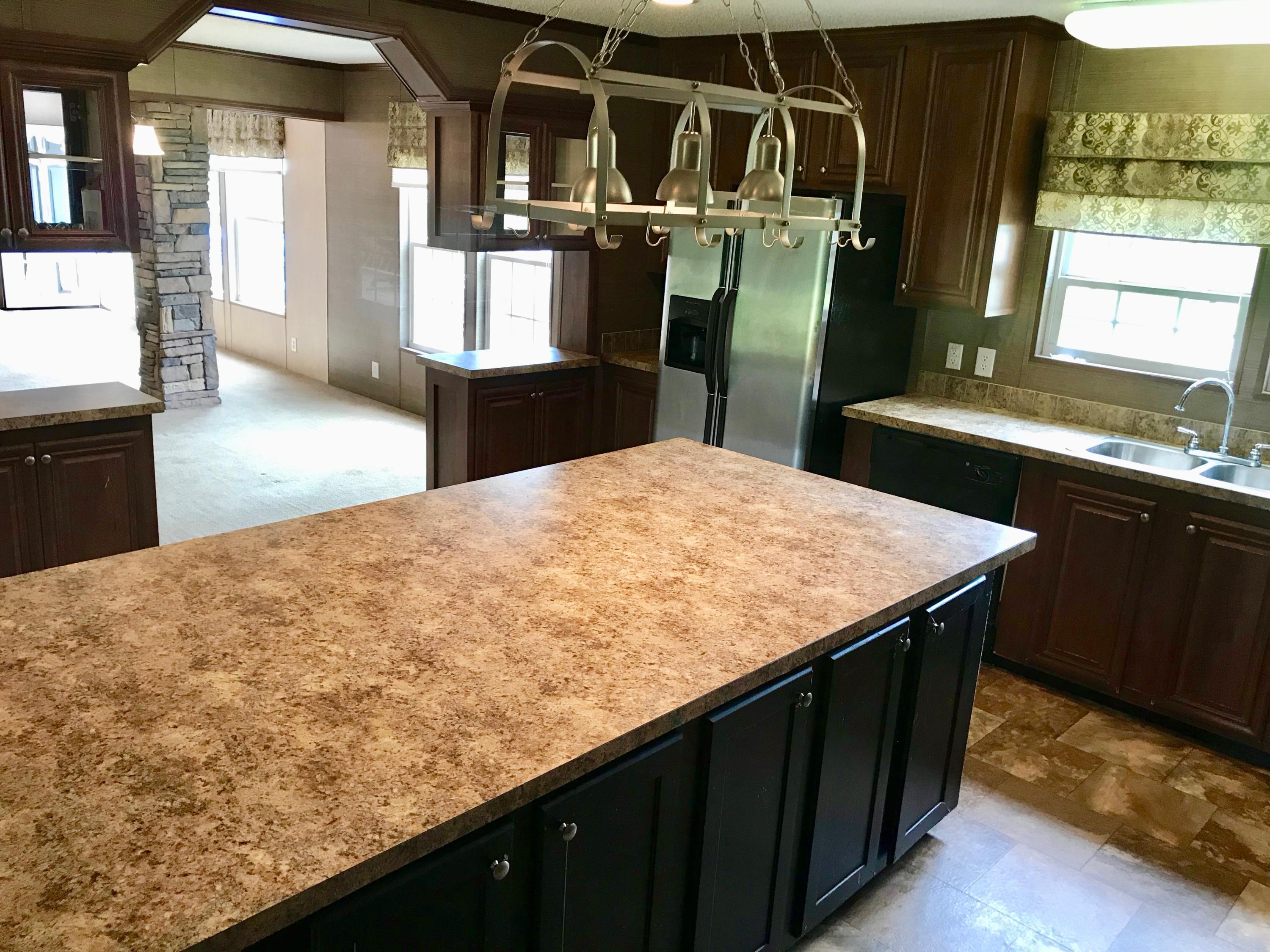 9840 American Farms Road Milton, FL 32583 - Photo 10 of 42 a kitchen with kitchen island sink stove and refrigerator