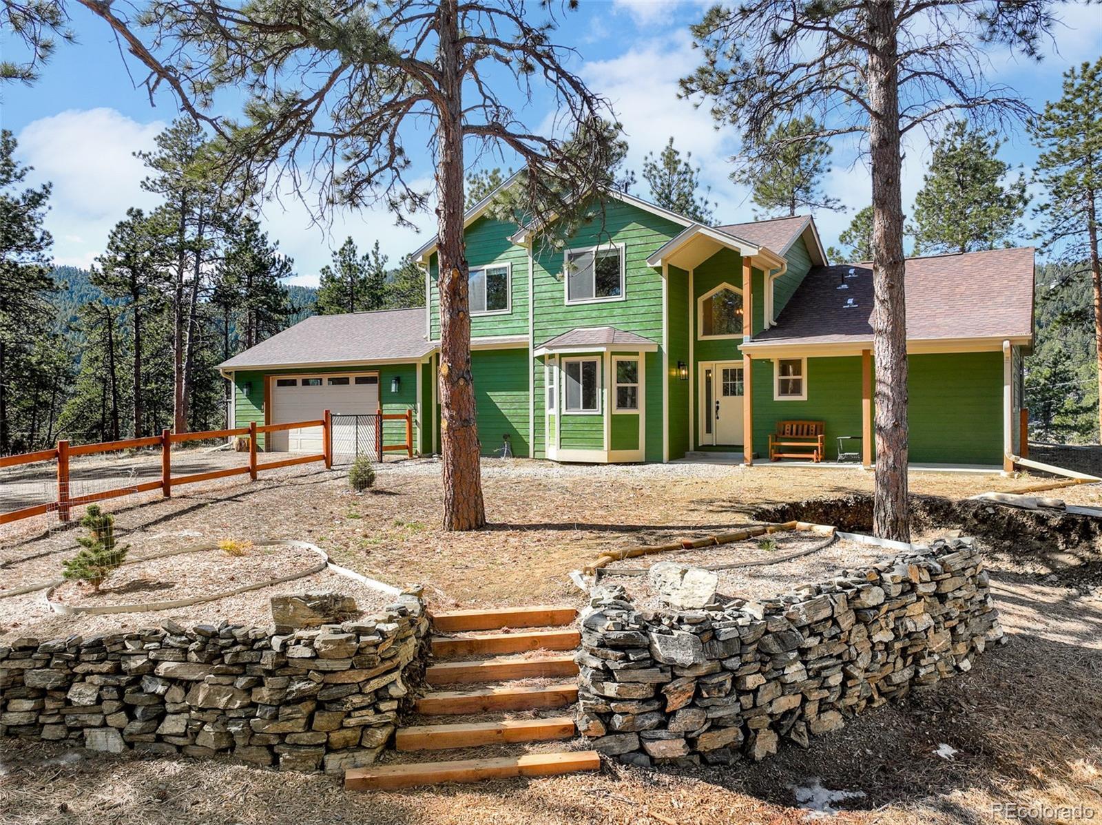 5132 Ute Road Indian Hills, CO 80454 - Photo 2 of 38 a front view of a house with a garden