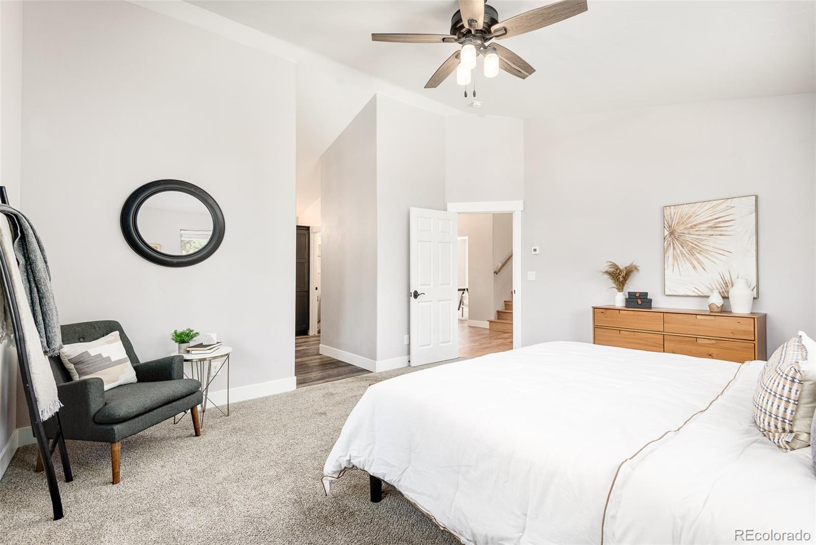 5132 Ute Road Indian Hills, CO 80454 - Photo 23 of 38 a bedroom with a bed a chandelier and a mirror