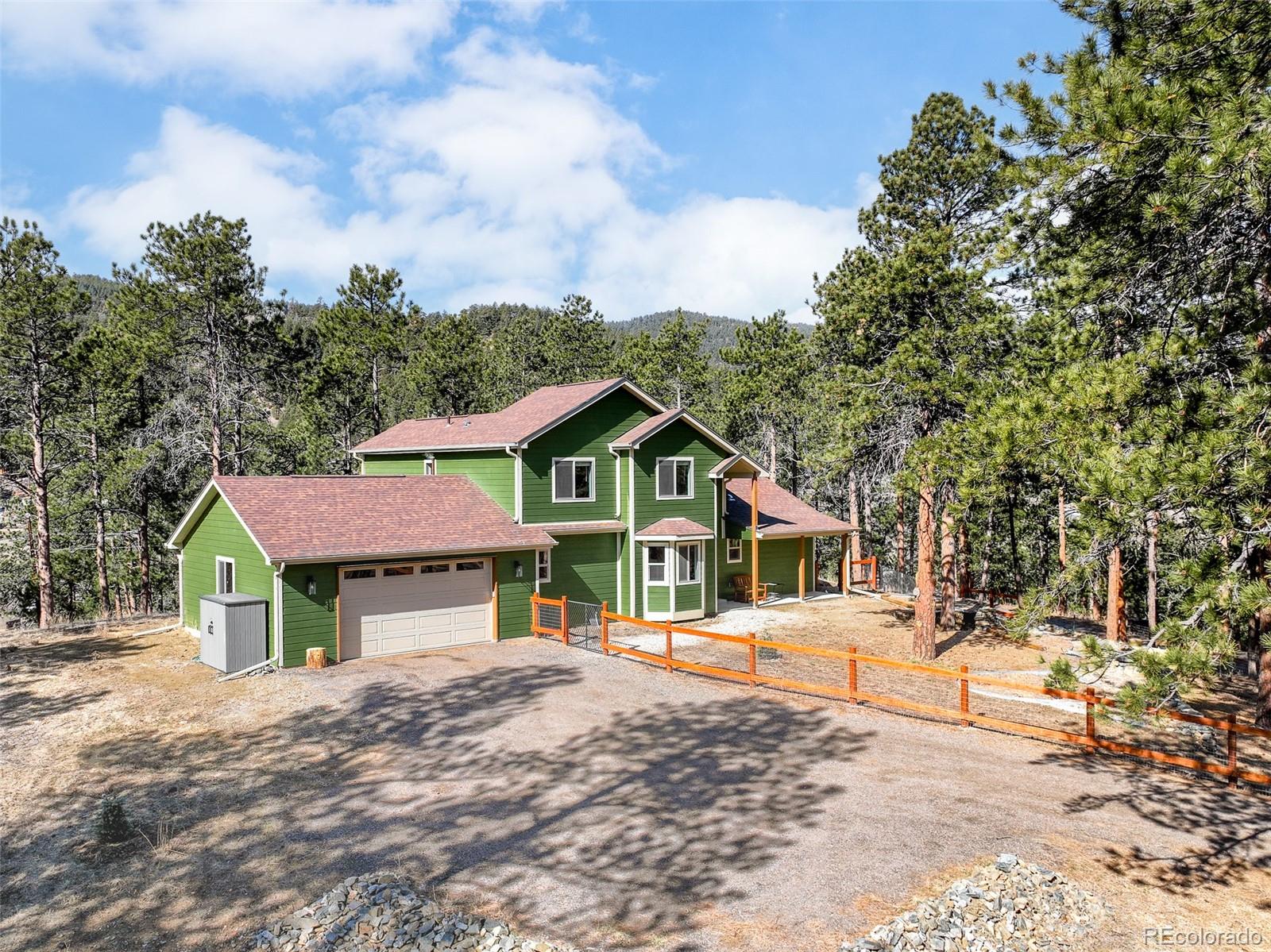 5132 Ute Road Indian Hills, CO 80454 - Photo 3 of 38 a view of a house with a yard and large trees