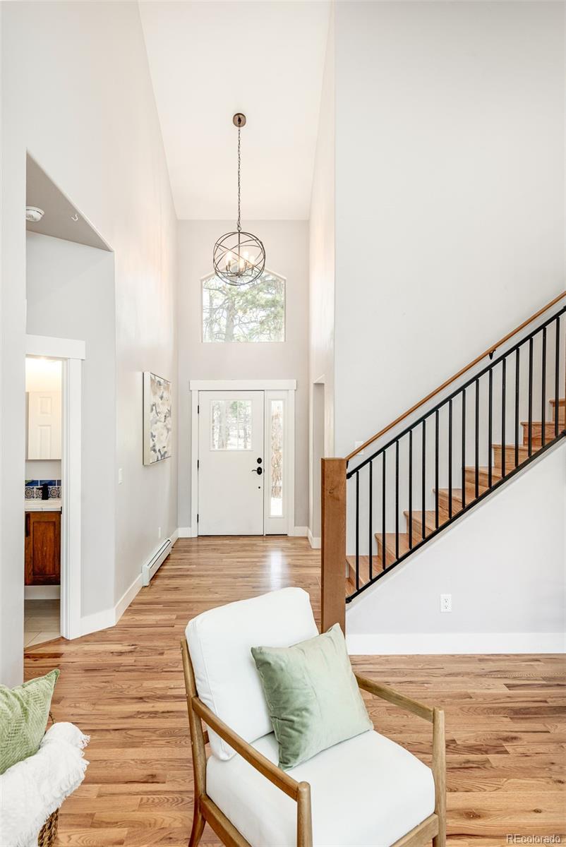5132 Ute Road Indian Hills, CO 80454 - Photo 5 of 38 a view of a hallway with furniture and wooden floor