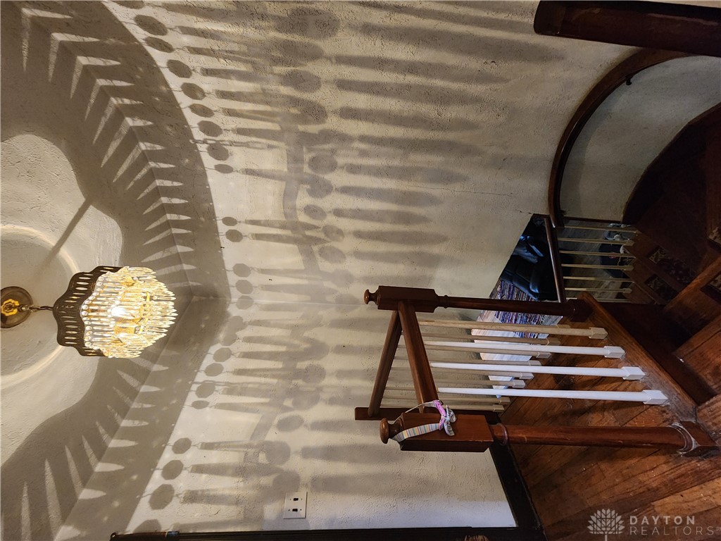 1436 Ruskin Road Dayton, OH 45406 - Photo 13 of 29 Elegant spiral staircase with wood flooring and intricate chandelier lighting.