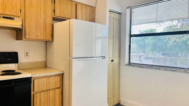 a white refrigerator freezer sitting next to a window