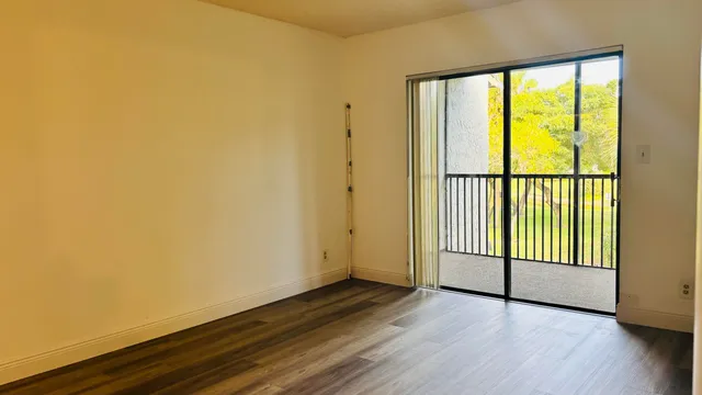 a view of a room with wooden floor and a window