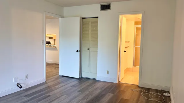 an empty room with wooden floor and closet