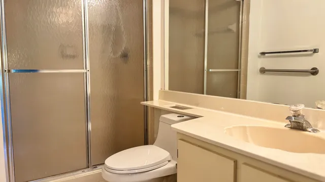 a bathroom with a sink a toilet and shower