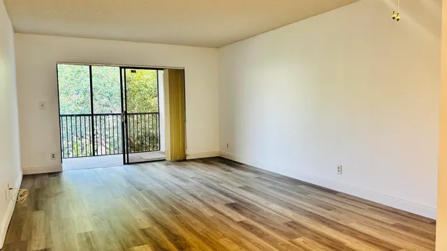 a view of a room with wooden floor and a window