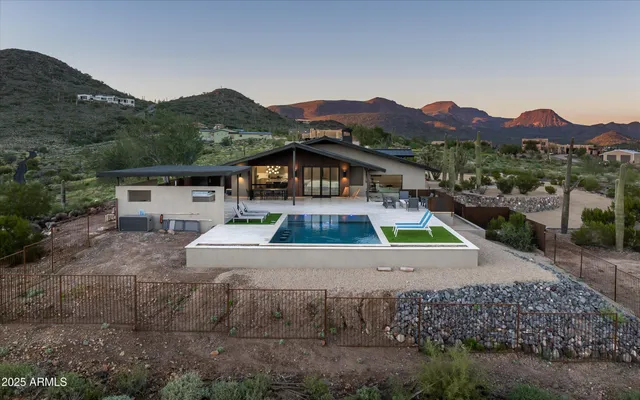 a view of house with swimming pool and mountains in the background