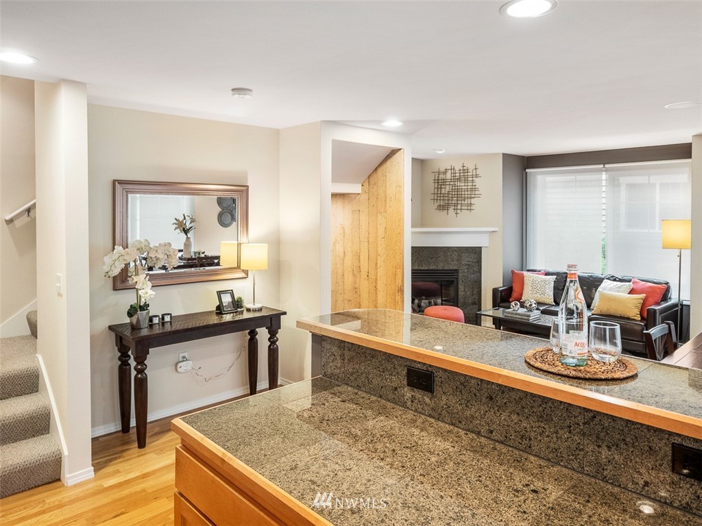 1212 North 85th Street, Unit B Seattle, WA 98103 - Photo 11 of 28 a kitchen with stainless steel appliances granite countertop a sink stove and wooden cabinets