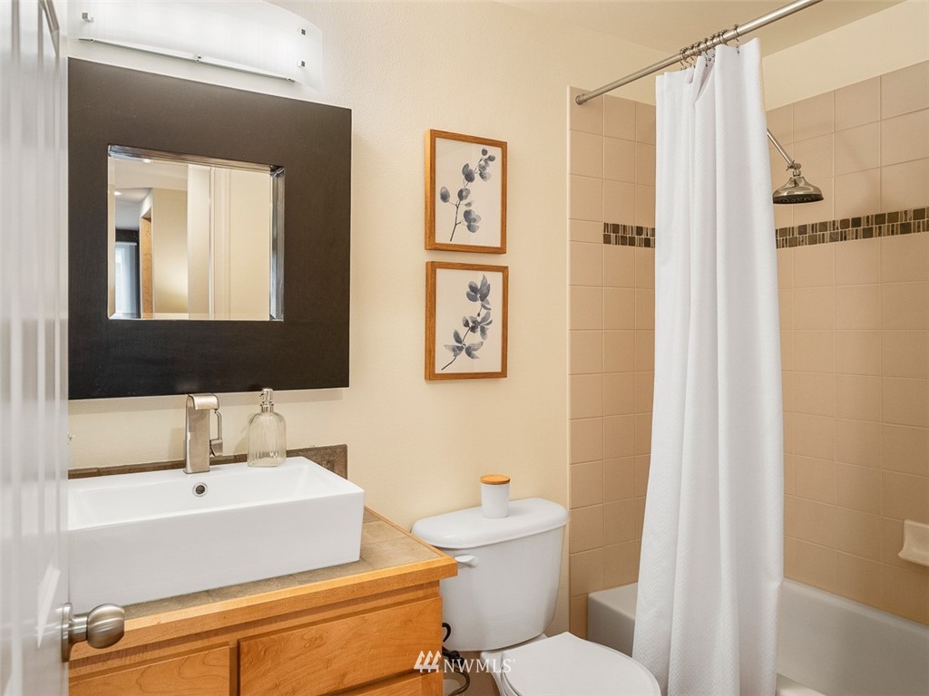 1212 North 85th Street, Unit B Seattle, WA 98103 - Photo 12 of 28 a bathroom with a toilet a sink and a mirror