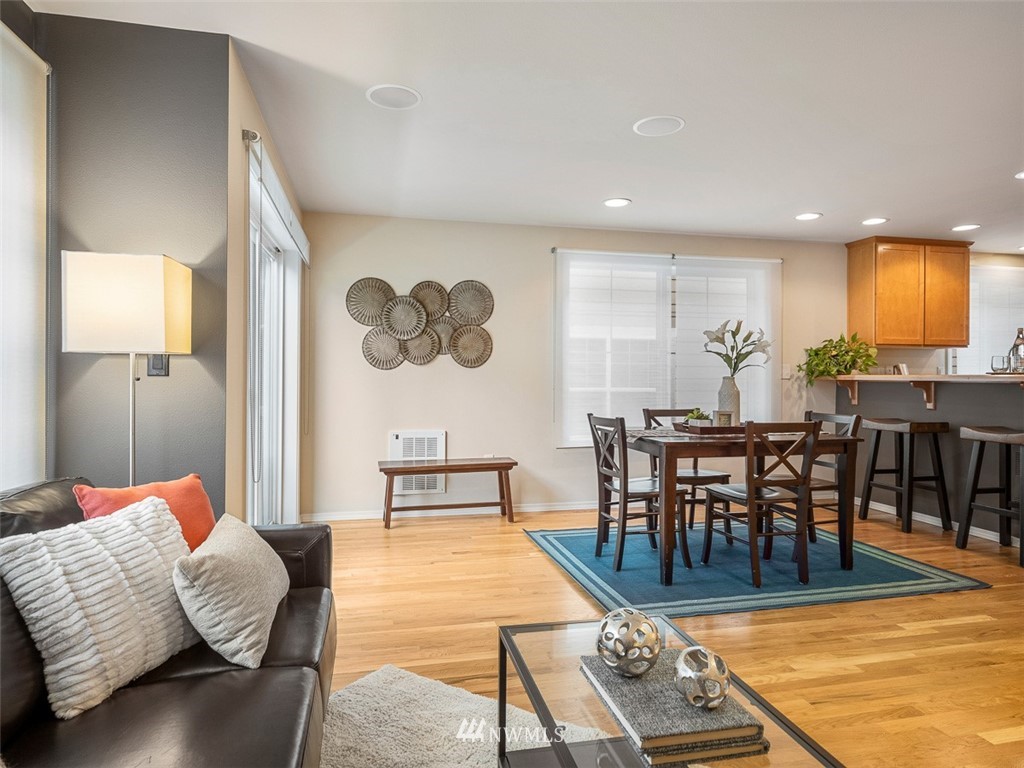 1212 North 85th Street, Unit B Seattle, WA 98103 - Photo 3 of 28 a living room with couches chairs and a dining table with wooden floor