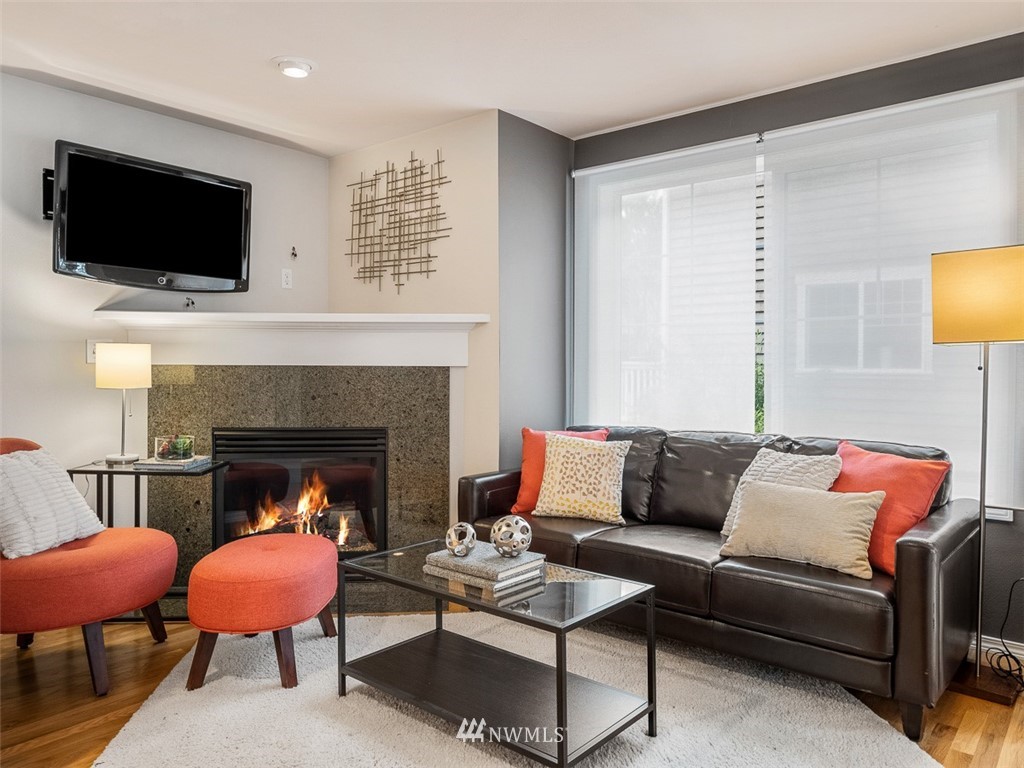 1212 North 85th Street, Unit B Seattle, WA 98103 - Photo 7 of 28 a living room with furniture a flat screen tv and a fireplace