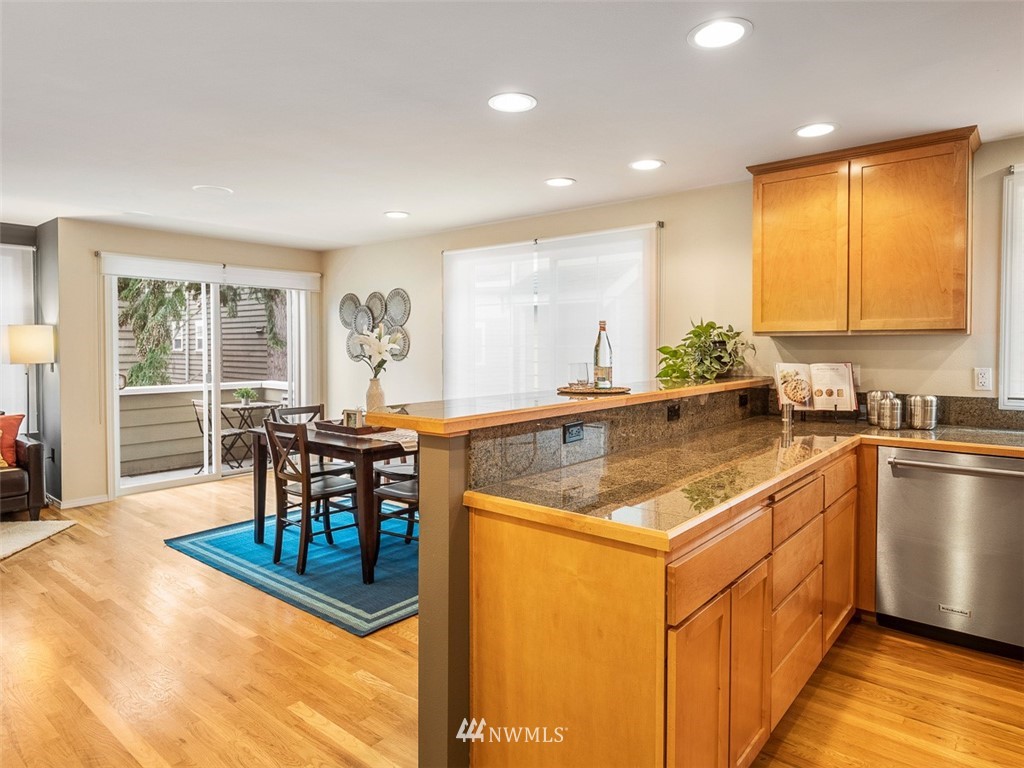 1212 North 85th Street, Unit B Seattle, WA 98103 - Photo 10 of 28 a kitchen with stainless steel appliances granite countertop sink stove and table