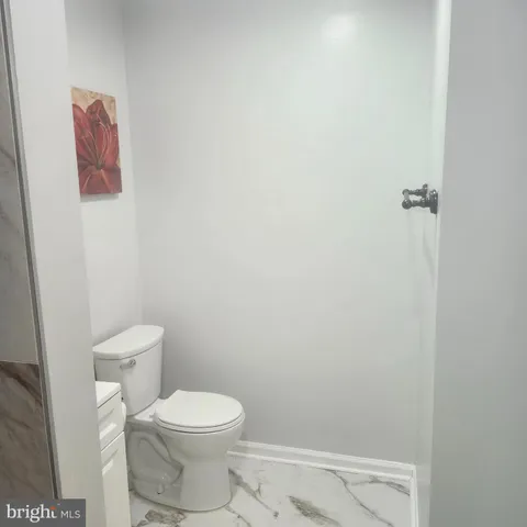 a white toilet sitting next to a shower