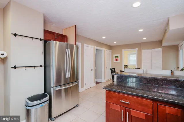 a bathroom with a granite countertop toilet sink and mirror