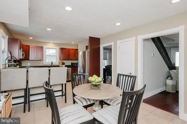 a bathroom with a toilet a sink a mirror and a window