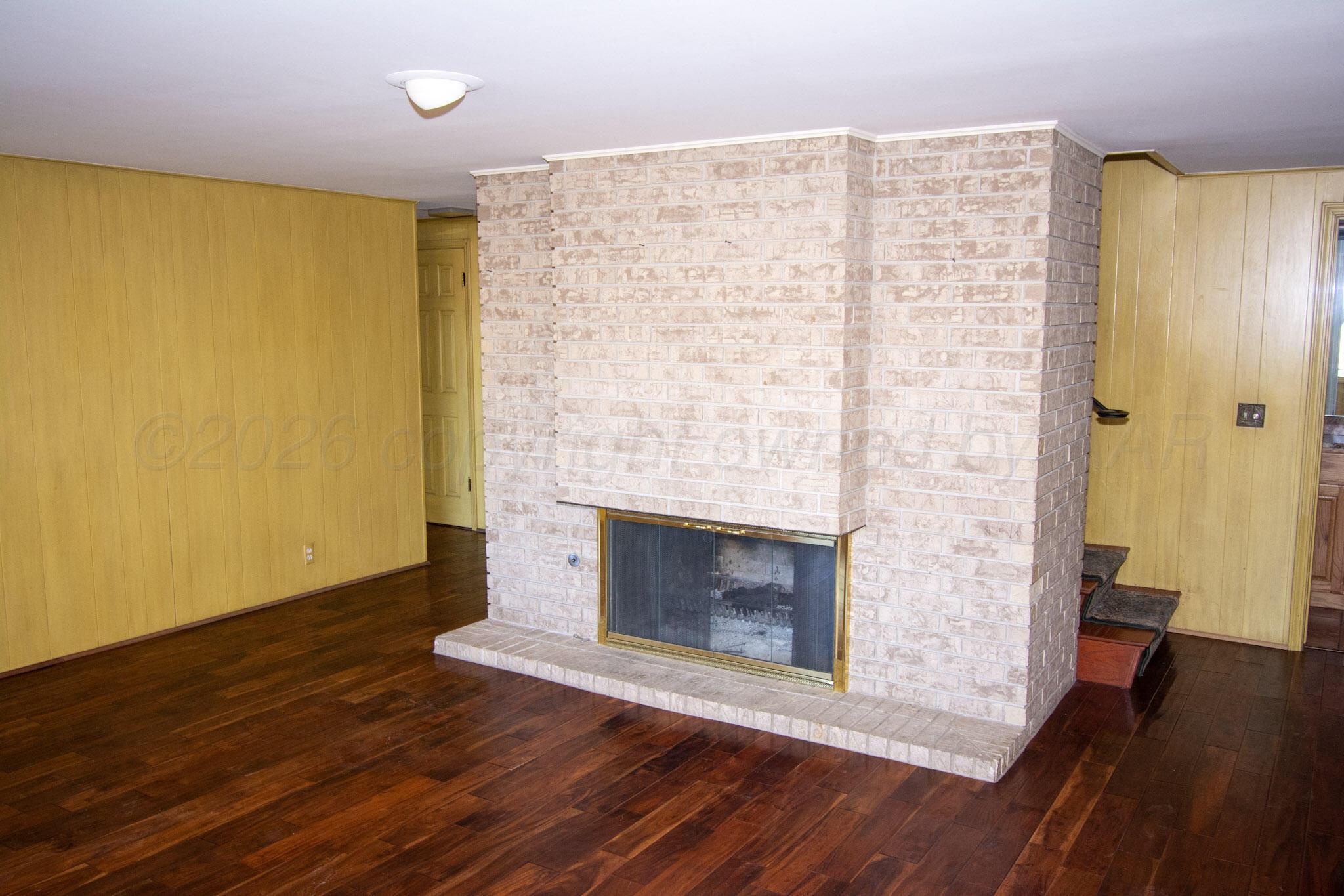 4 Windsor Road Amarillo, TX 79124 - Photo 19 of 41 a view of an empty room with wooden floor and a fireplace