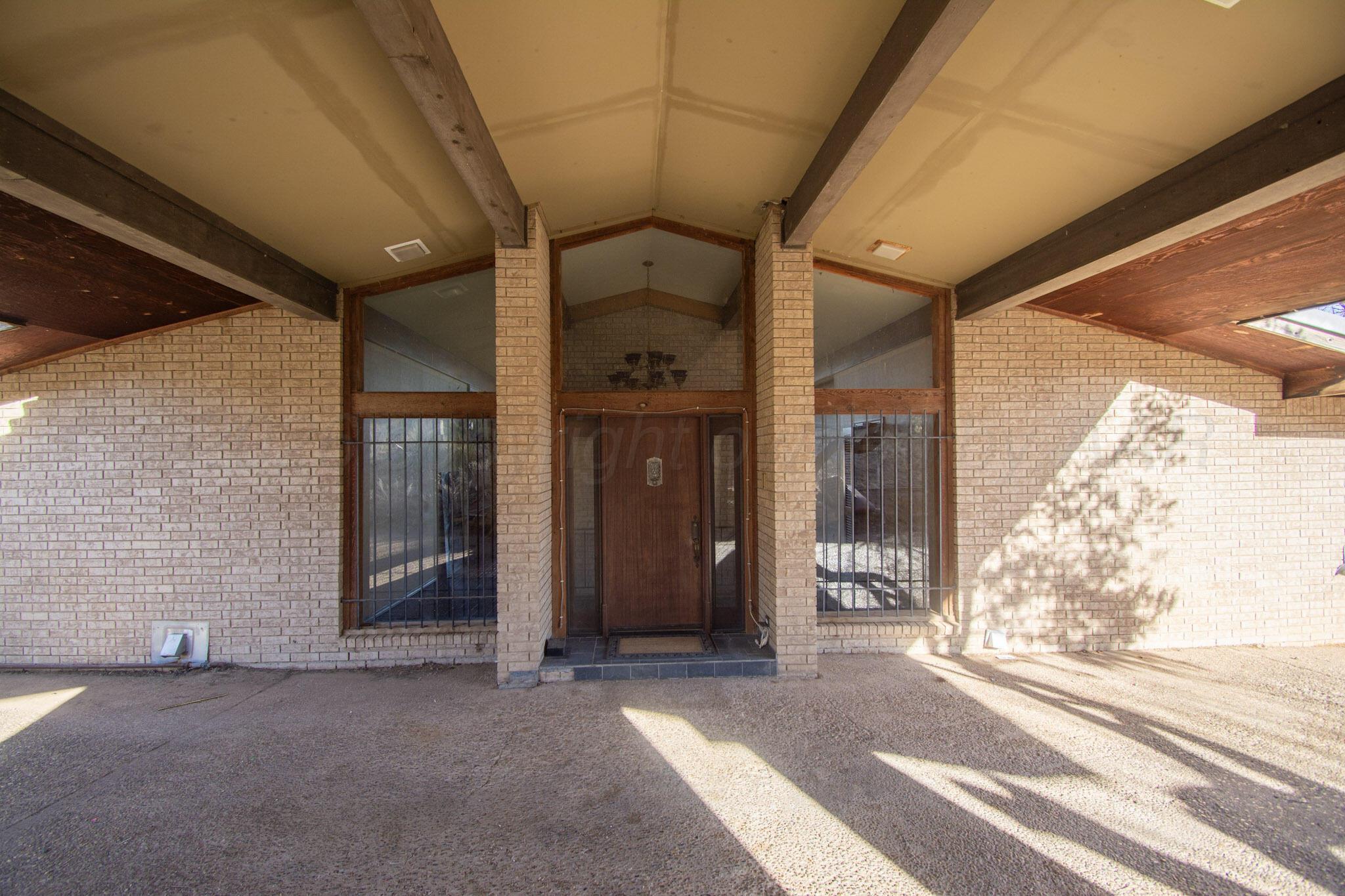 4 Windsor Road Amarillo, TX 79124 - Photo 2 of 41 a view of a hallway with wooden shelves and a couch