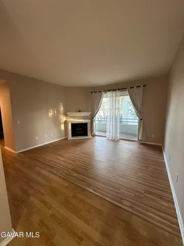 an empty room with wooden floor and fireplace
