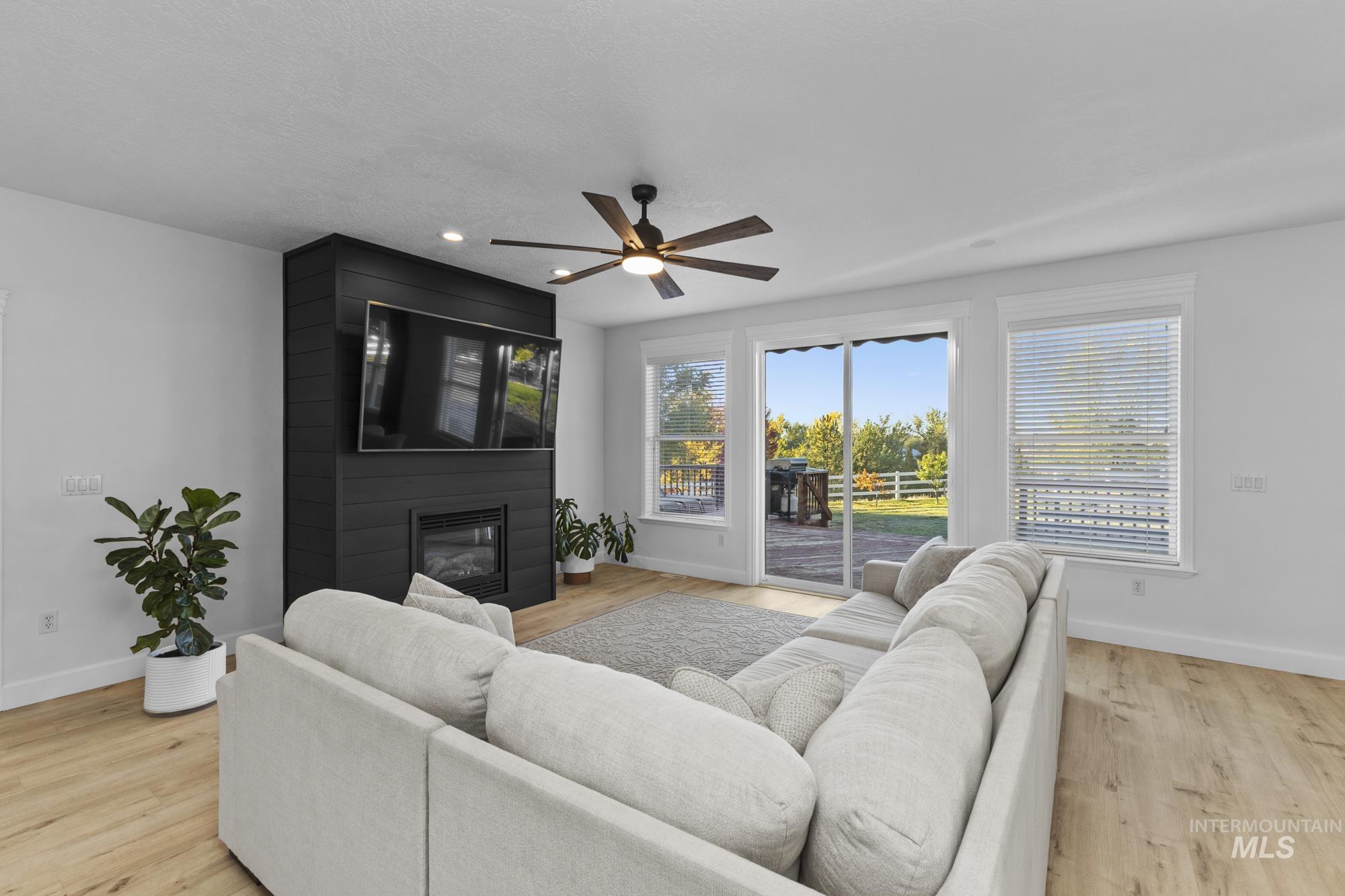 14820 Worden Way Caldwell, ID 83607 - Photo 19 of 44 Living room with plenty of natural light, a ceiling fan, light wood finished floors, and a large fireplace