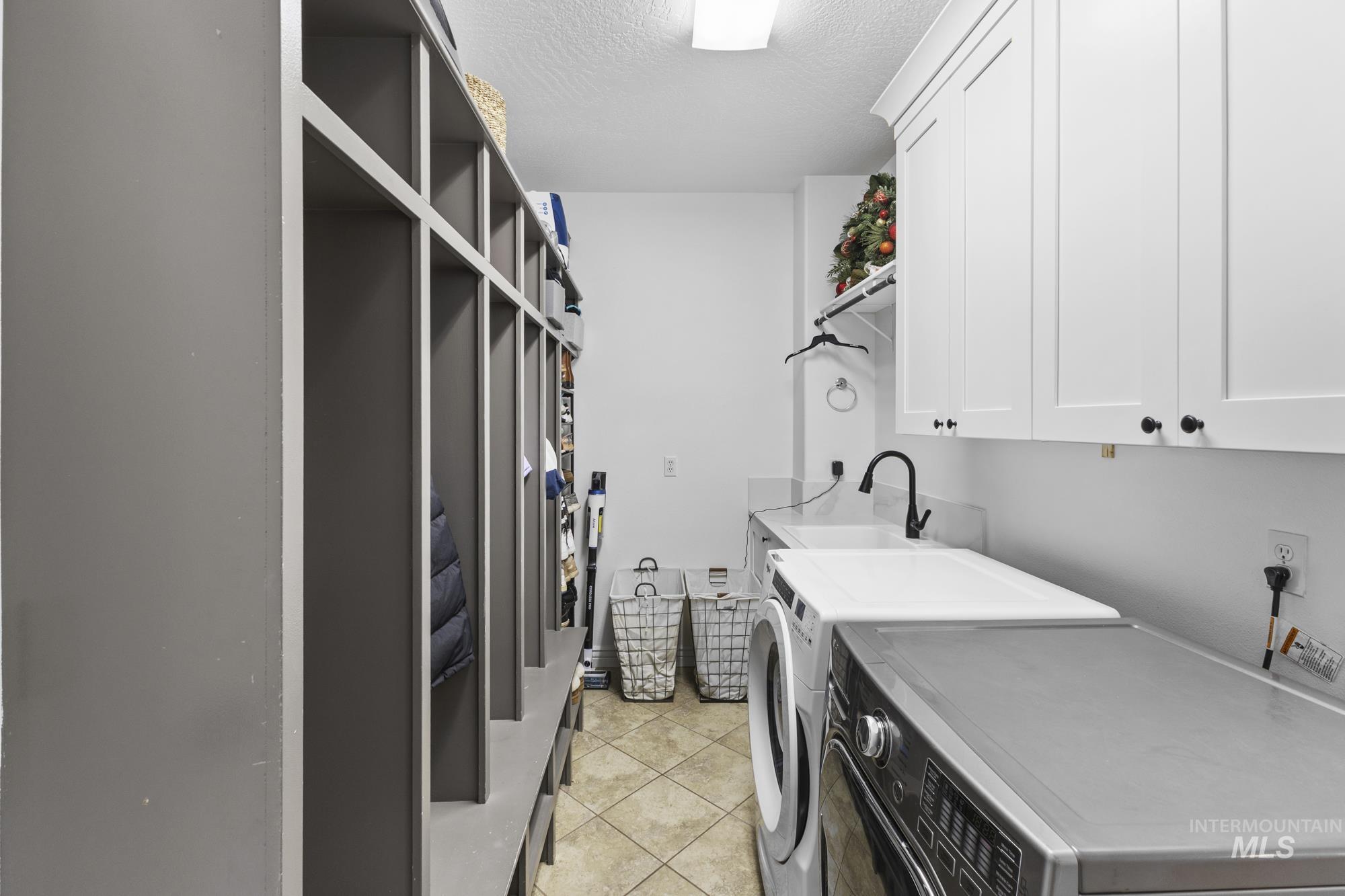 14820 Worden Way Caldwell, ID 83607 - Photo 22 of 44 Laundry area with cabinet space, a textured ceiling, washer and clothes dryer, and light tile patterned flooring