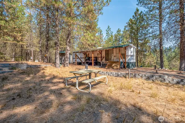 a view of a house with backyard and trees
