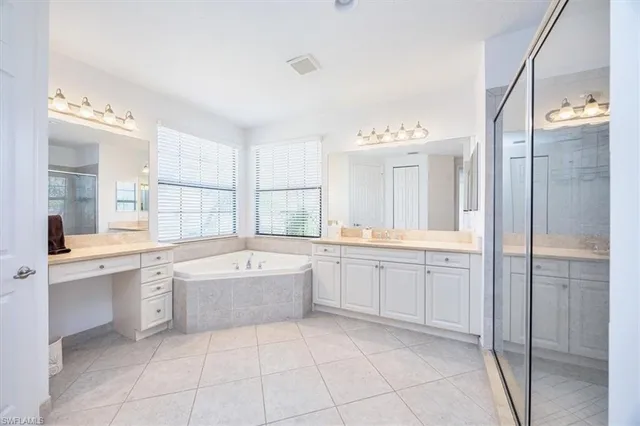 a spacious bathroom with a granite countertop tub sink shower and mirror