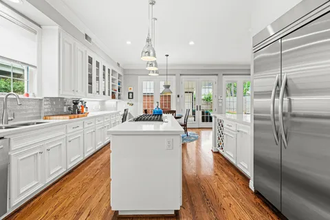 a kitchen with kitchen island a counter top space a sink appliances and cabinets