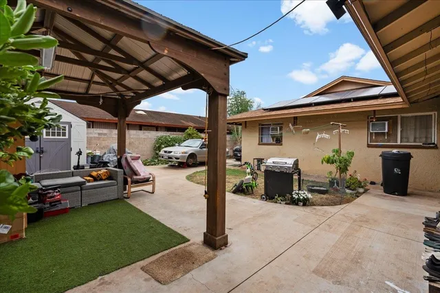 a view of a patio with table and chairs potted plants and a barbeque