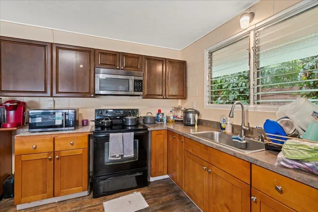 a kitchen with stainless steel appliances granite countertop a sink stove and cabinets