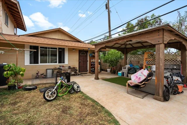 a view of an chairs and table in patio in front of a house