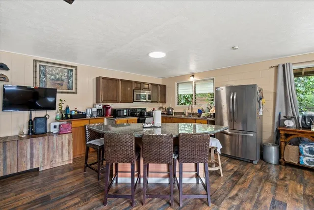 a view of a dining room with furniture a rug and wooden floor
