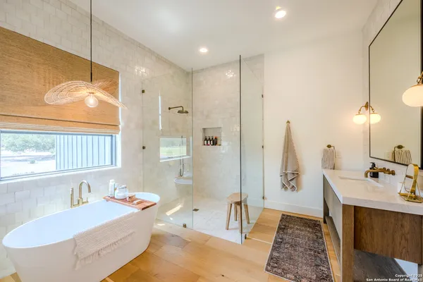 a bathroom with a tub sink and mirror