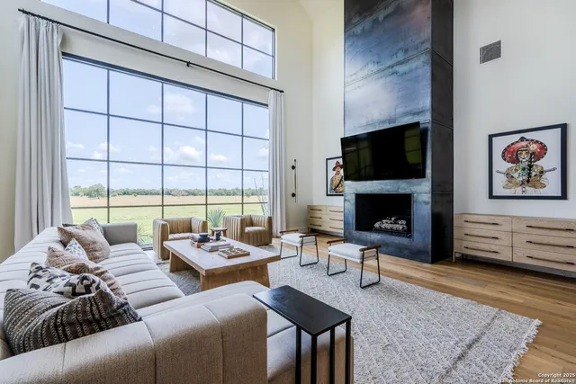 a living room with furniture large window and a flat screen tv