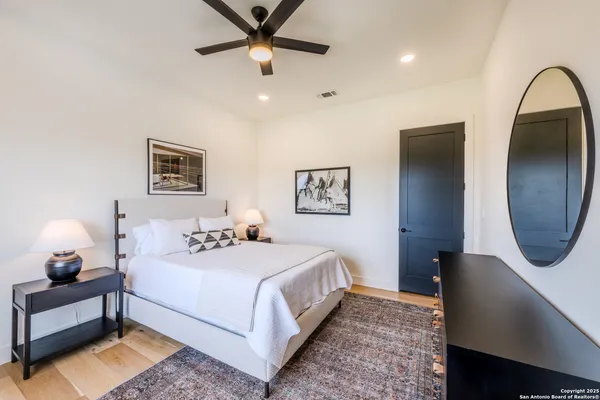 a bedroom with a bed lamp and a large mirror