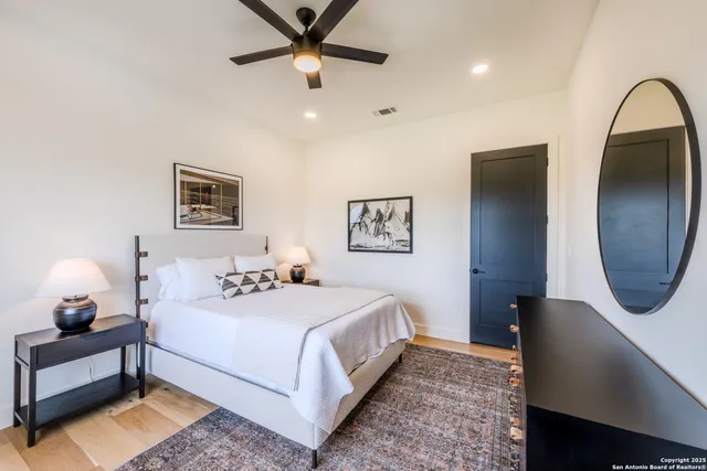 a bedroom with a bed lamp and a large mirror