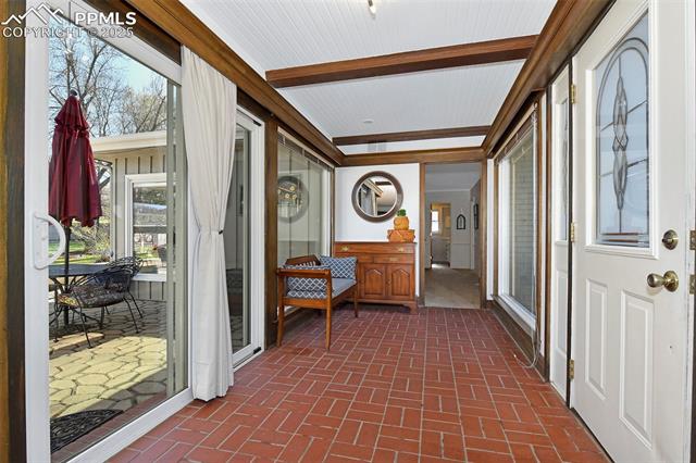 2421 Strickler Road Colorado Springs, CO 80906 - Photo 7 of 44 Sunroom featuring beamed ceiling