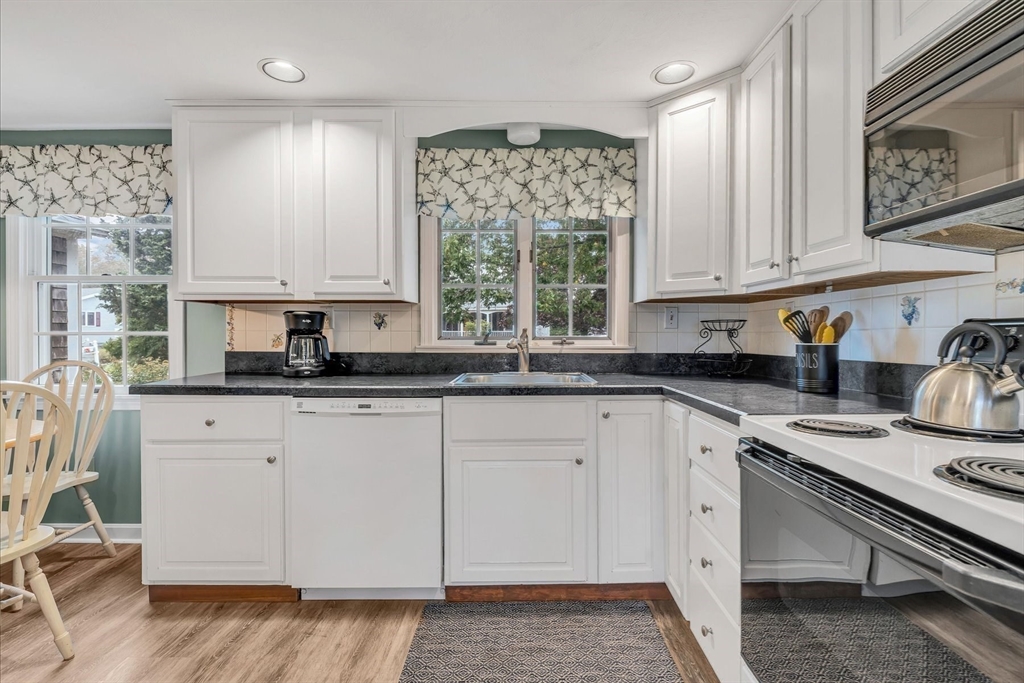 30 Cove Road Eastham, MA 02642 - Photo 15 of 42 a kitchen with stainless steel appliances granite countertop a stove a sink and white cabinets