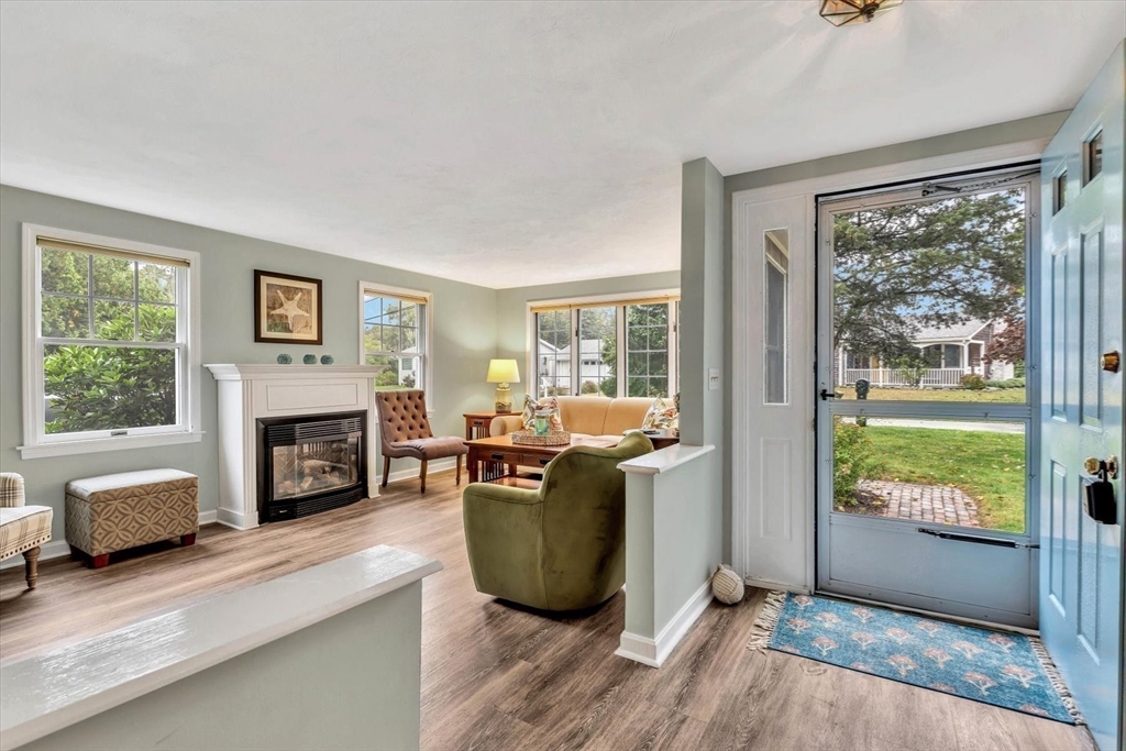 30 Cove Road Eastham, MA 02642 - Photo 9 of 42 a living room with furniture a fireplace and a floor to ceiling window