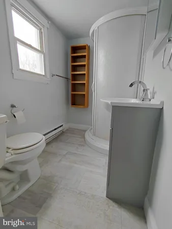 a bathroom with a sink a toilet and a window