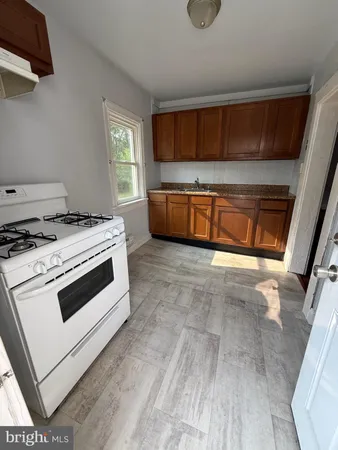 a kitchen with granite countertop a stove a sink and a microwave
