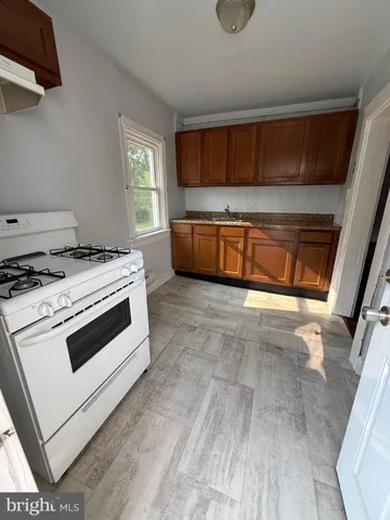 a kitchen with granite countertop a stove a sink and a microwave
