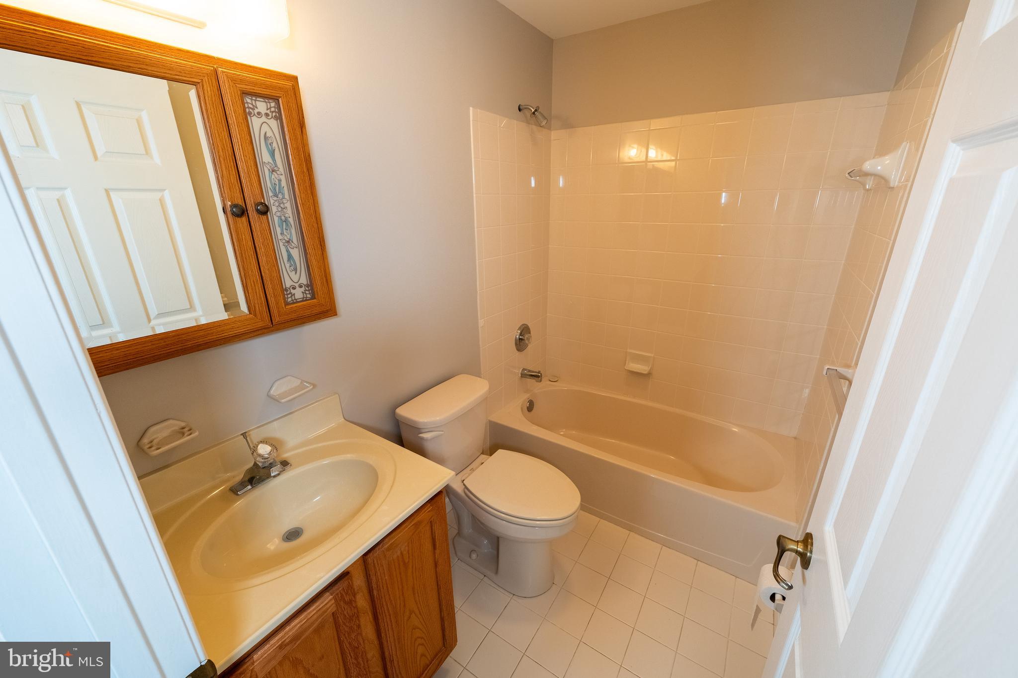 6506 Ridenour Way East, Unit 3A Eldersburg, MD 21784 - Photo 12 of 24 a bathroom with a sink a toilet a mirror and a shower