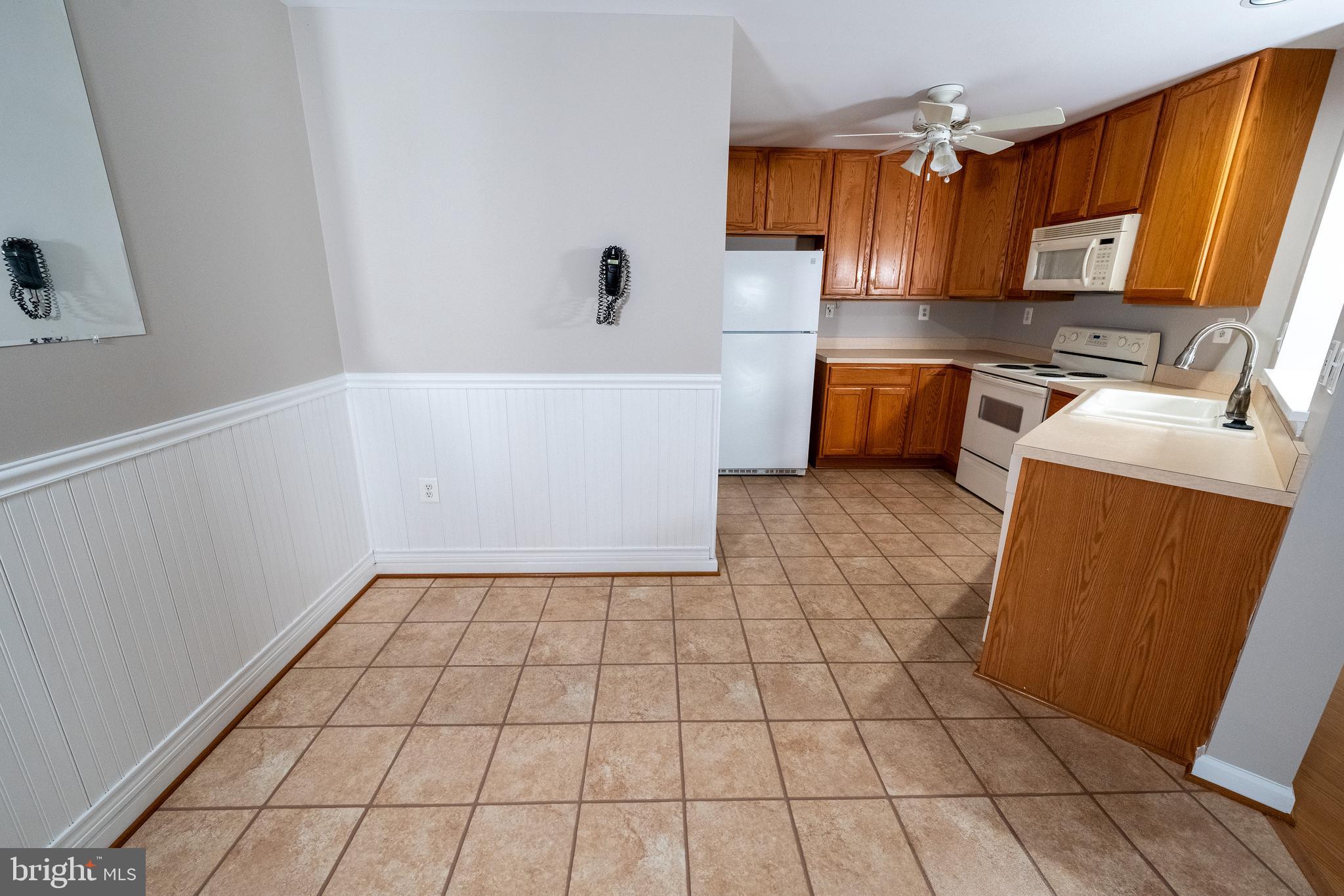 6506 Ridenour Way East, Unit 3A Eldersburg, MD 21784 - Photo 4 of 24 a kitchen with a sink a stove a microwave and cabinets