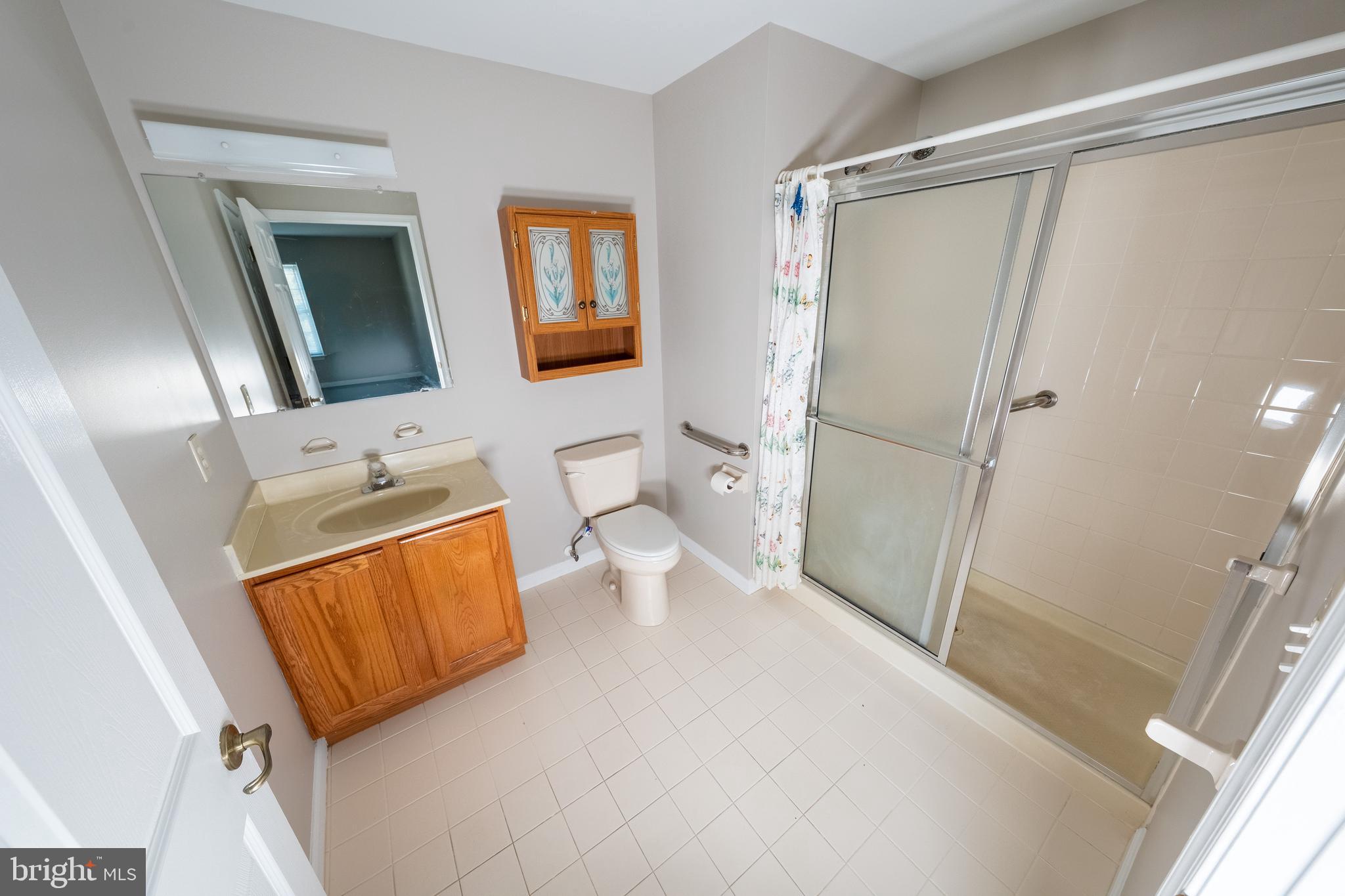 6506 Ridenour Way East, Unit 3A Eldersburg, MD 21784 - Photo 9 of 24 a bathroom with a sink a toilet and shower