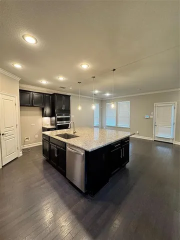 a kitchen with stainless steel appliances kitchen island granite countertop a stove and a refrigerator
