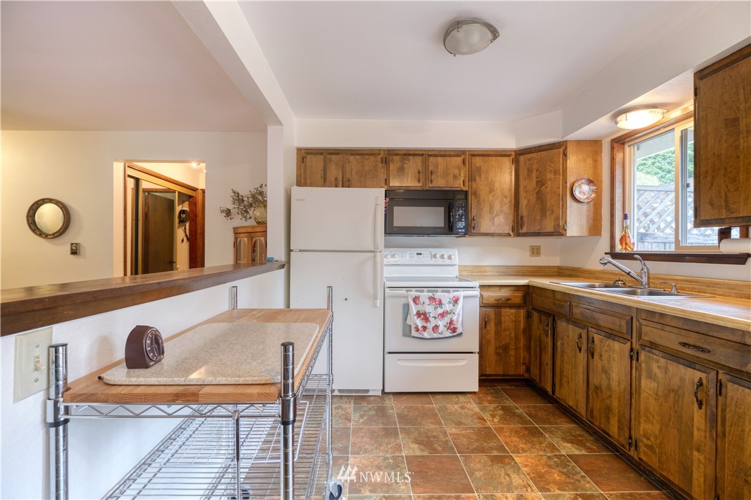 542 Boundary Bay Road Point Roberts, WA 98281 - Photo 7 of 23 a kitchen with a stove a sink and a microwave
