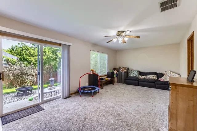 a living room with furniture a flat screen tv and a floor to ceiling window