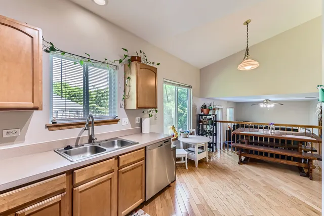 a kitchen with stainless steel appliances sink stove and wooden floor